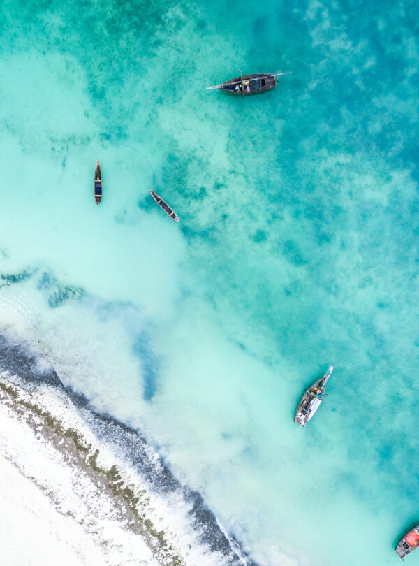 view of ocean with fishing boats and islad city coastline