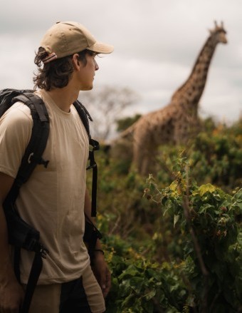 tourist walking and observing giraffe in arusha 340x440 1